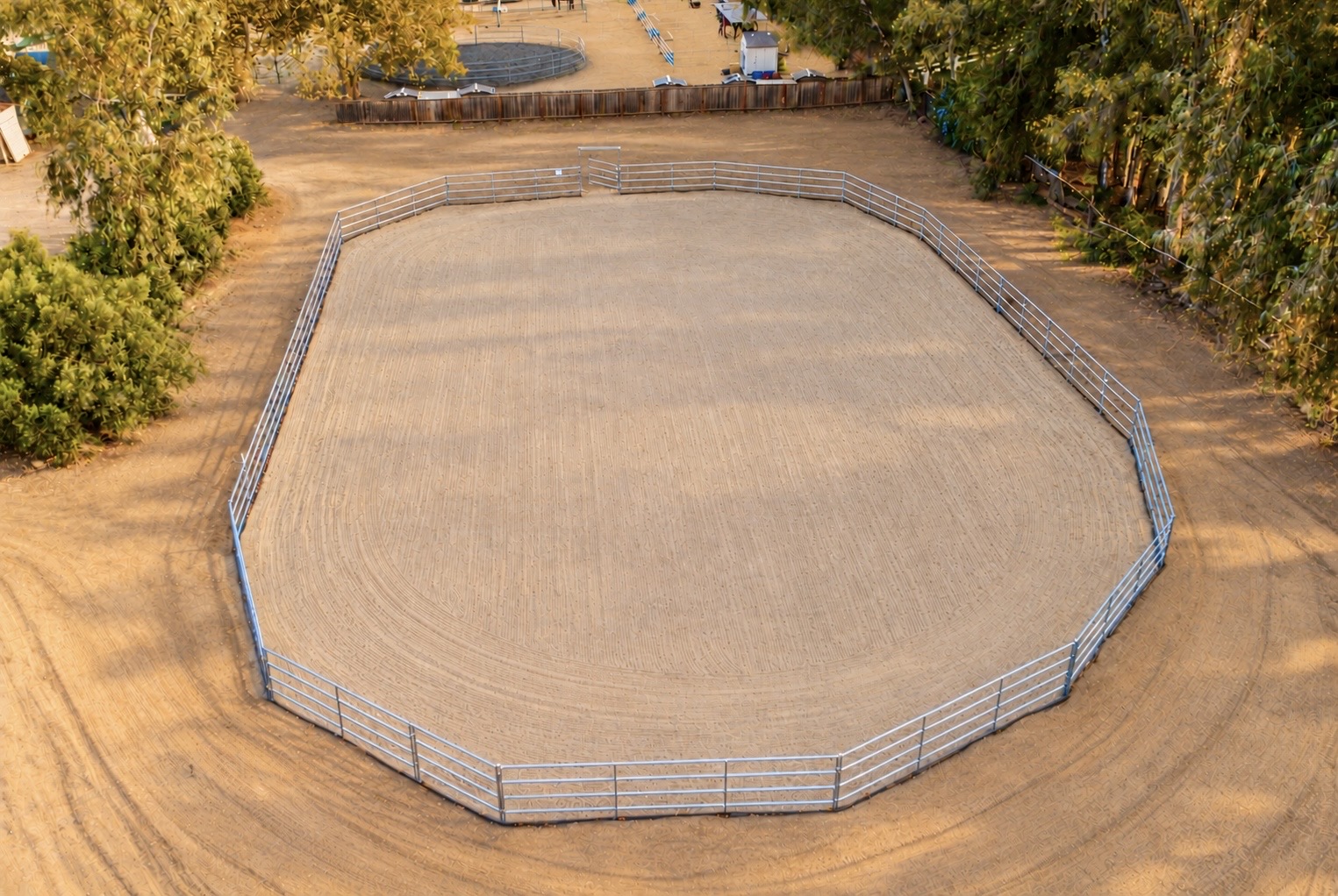 Aerial view of the groomed riding arena surrounded by trees at Silver Star Ranch